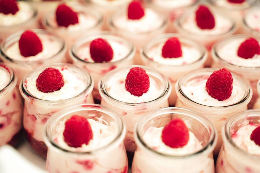 Rows of glasses with raspberry sweet dessert for Celebration, party, birthday