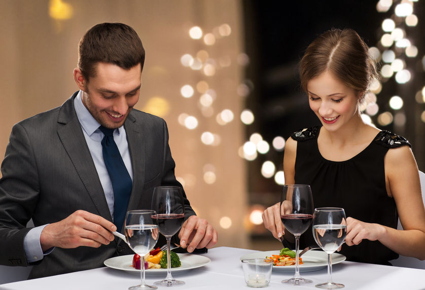 smiling couple eating main course at restaurant