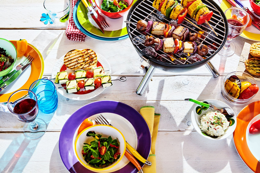 summer table with colorful dish and plates and brazier on white background with vegan bbq skewers